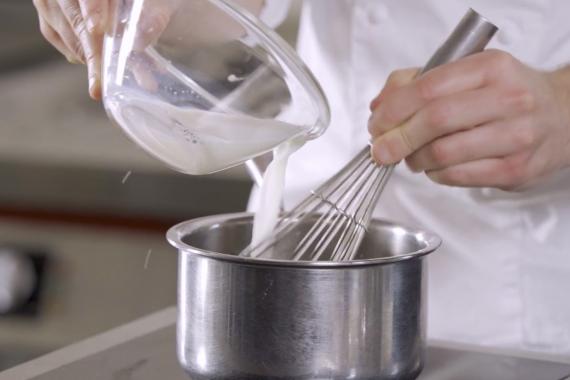 Vertiendo leche en la sartén.