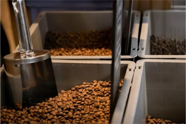 Bins of freshly roasted coffee beans at Monmouth Coffee, Borough Market, with a metal scoop ready for serving
