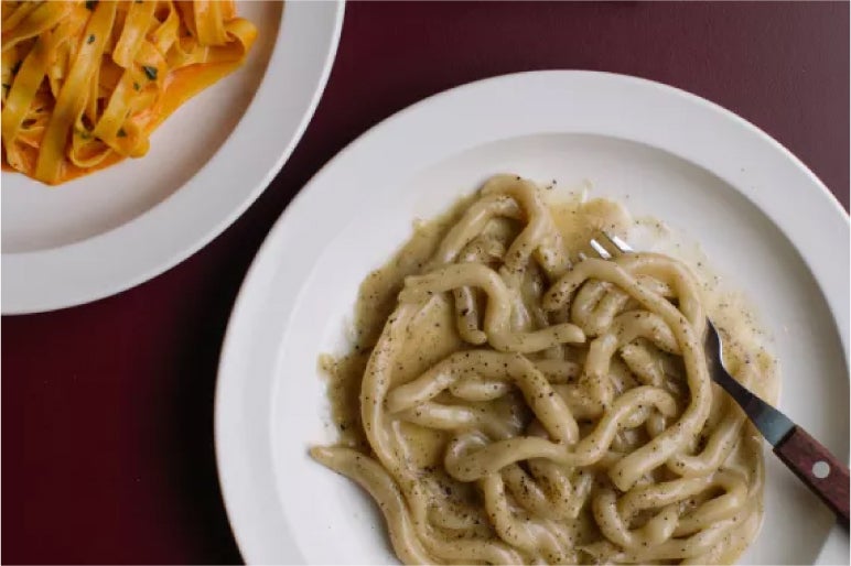 Two plates of pasta from Padella, Borough Market: one with buttery cacio e pepe, the other with a rich tomato-based sauce