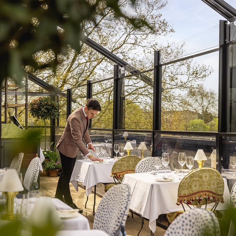 A waiter setting the table on the terrace at Scott's Richmond.