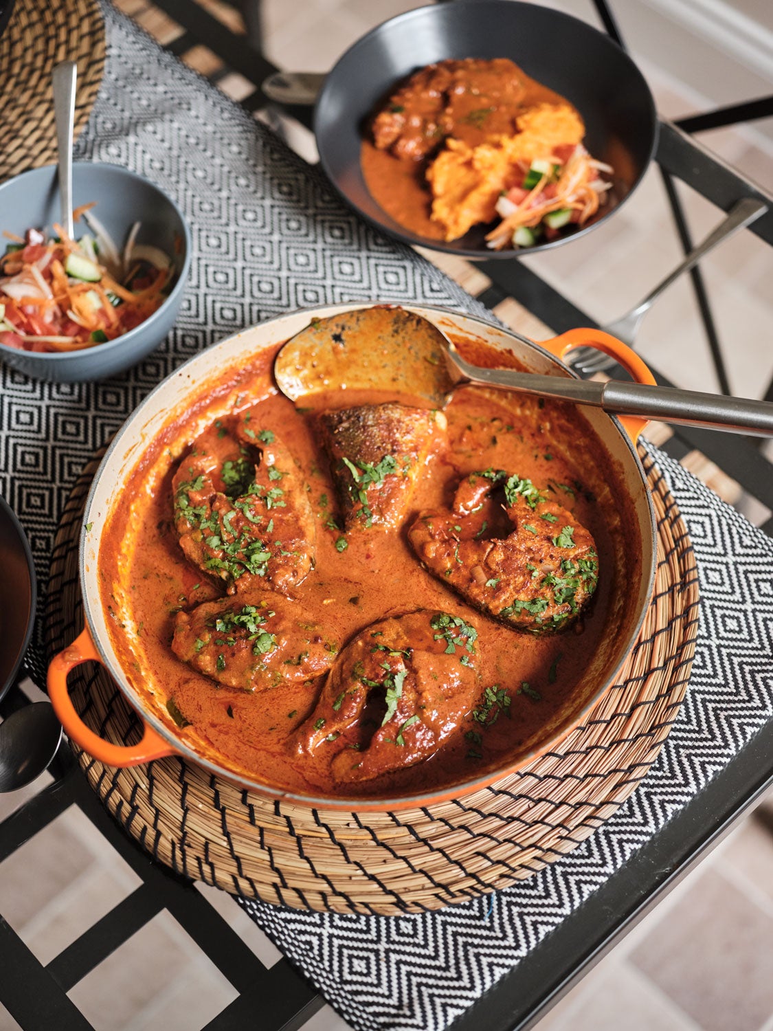 A bowl of food on a table with a spoon.