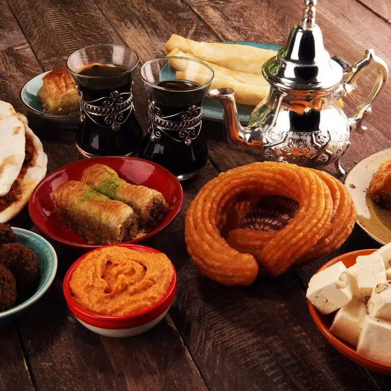 A table of halal food including sweet and savory snacks and black tea