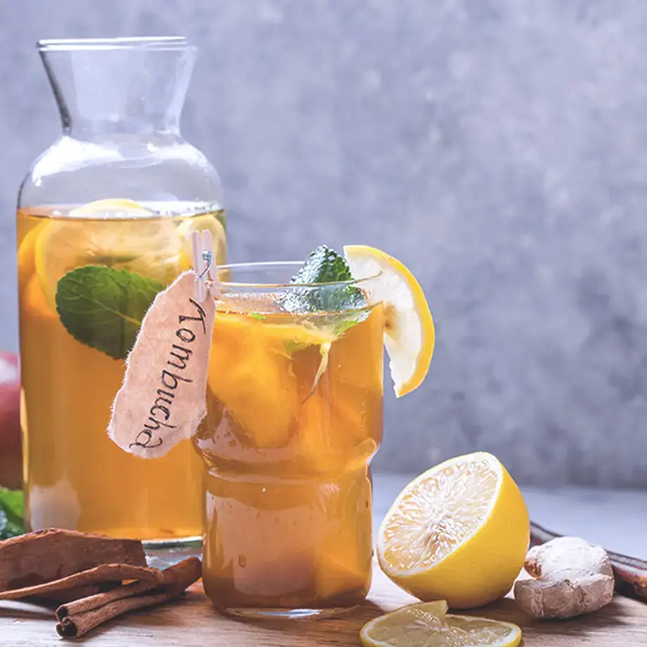 A carafe and glass of kombucha.