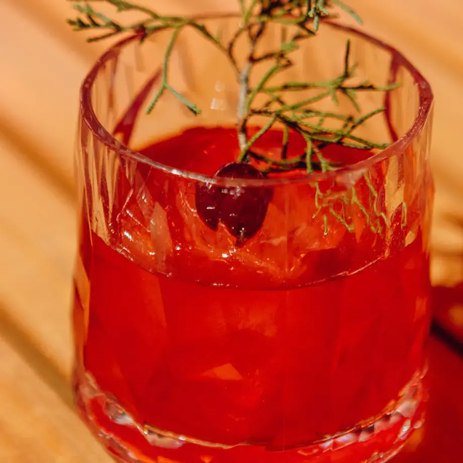 red cocktail in glass on table