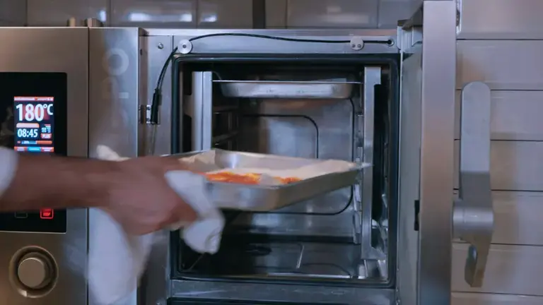 Preparation in the baking pan placed in the oven by the chef