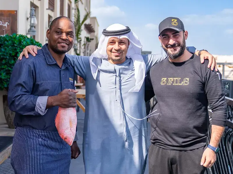 Three men smiling at the camera.