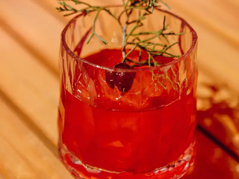 red cocktail in glass on table