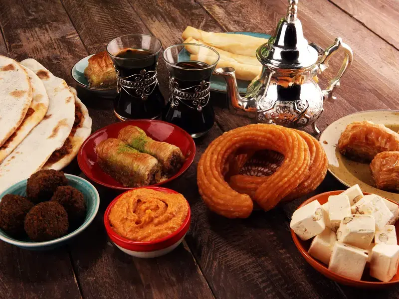 A table of halal food including sweet and savory snacks and black tea