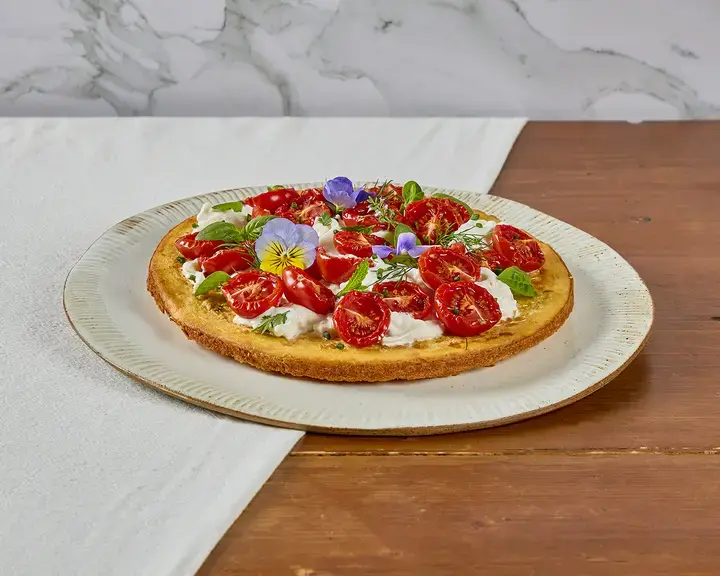 Crispy socca with stracciatella, confit tomatoes and Mediterranean herbs